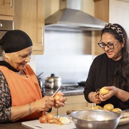 Older woman and younger woman chopping vegetables
