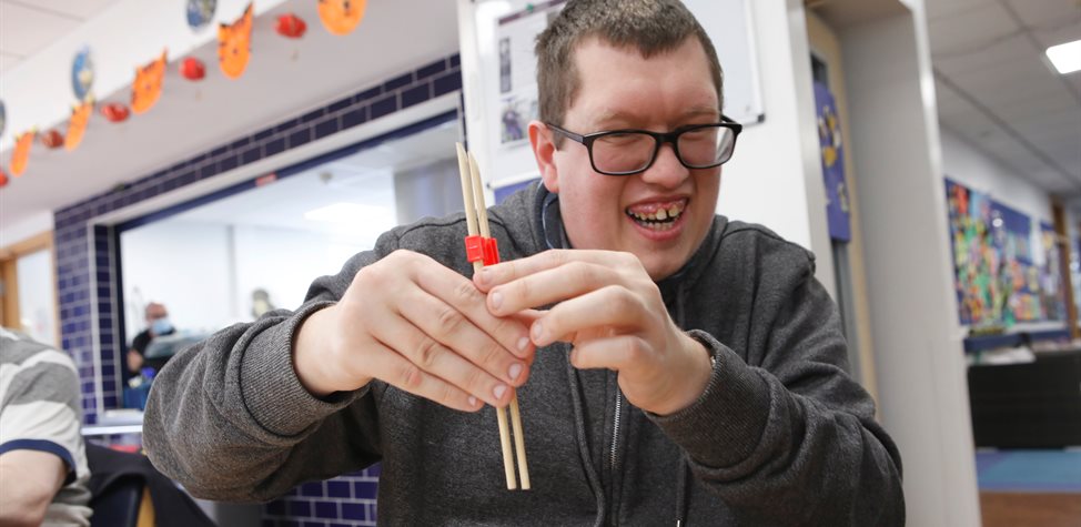 Young man using chopsticks