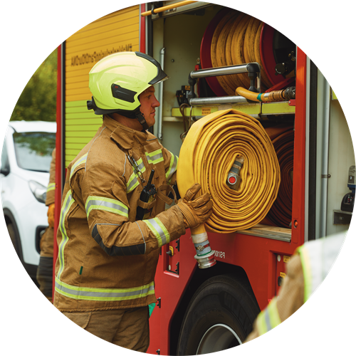 Firefighter reeling in a hose