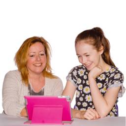 adult and teenager looking at an ipad