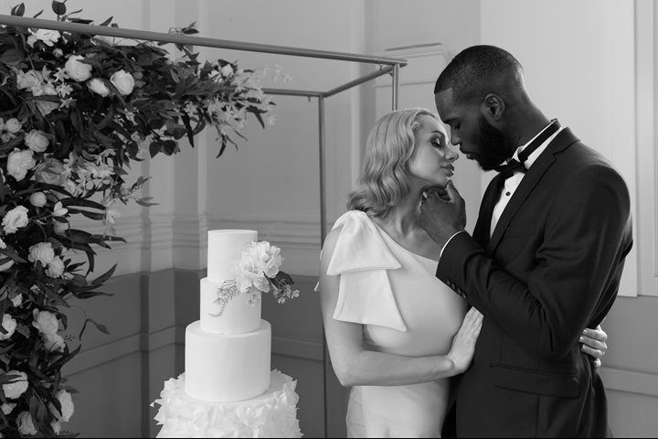 Bride and groom next to a wedding cake (black and white image)