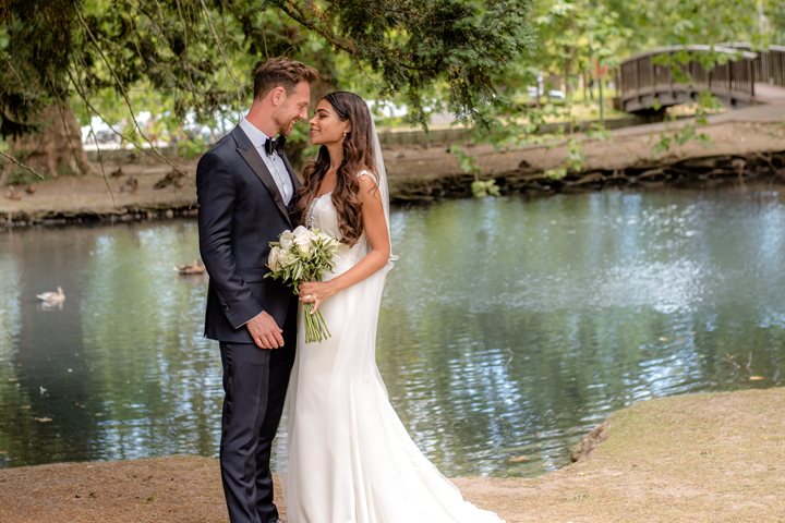 Bride and groom posing by a stream