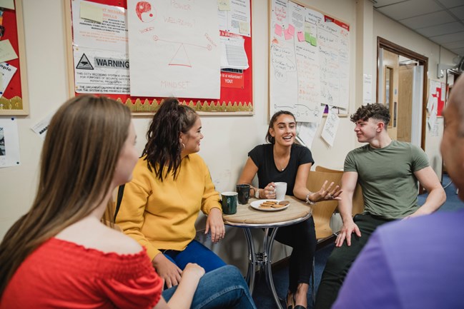 Young people having a happy discussion over a cup of tea